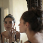 brunette woman looking in mirror